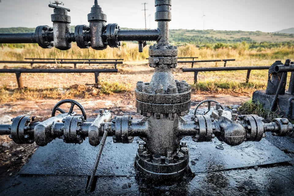 Close-up of dirty pipe at oil drilling operation.